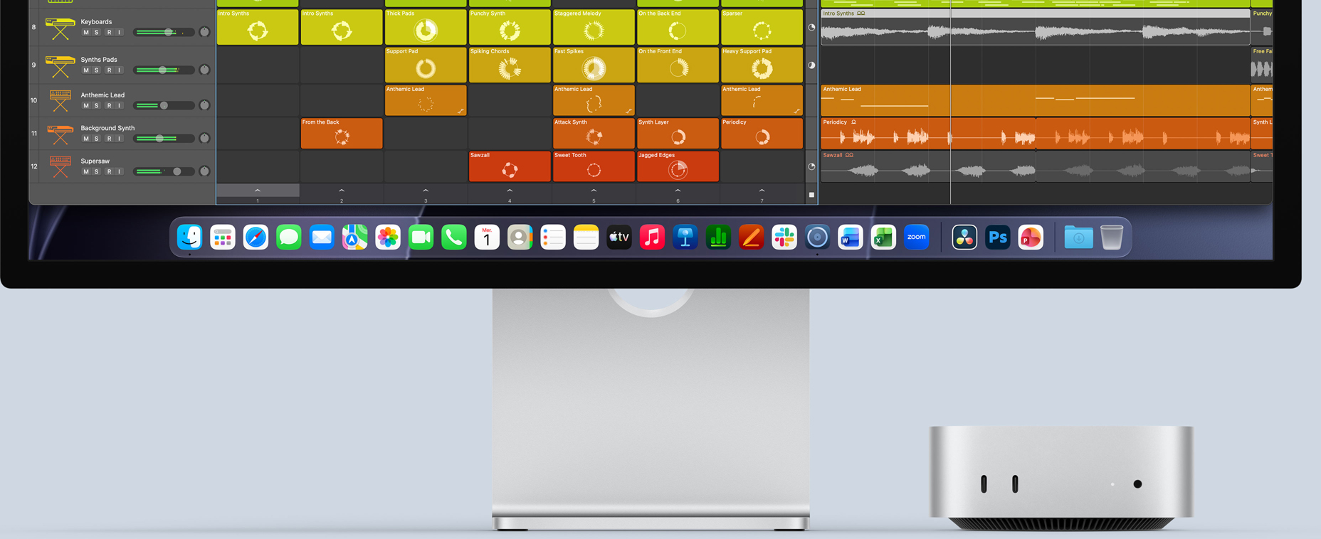 Face avant d’un Mac mini, posé sous un Studio Display, l’écran affiche l’interface de Logic Pro et des apps de productivité dans le Dock au bas de l’écran