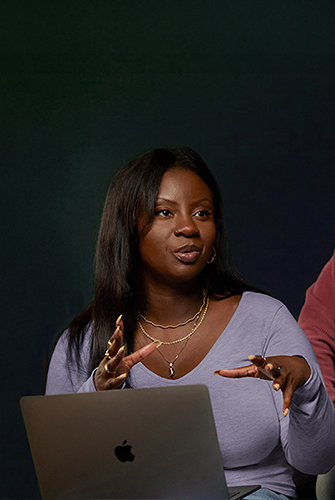 An Apple Software and Services team member sitting on a couch with a MacBook.