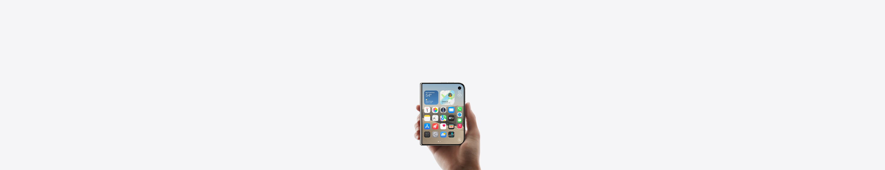iPhone Duo, color blanco estrella, lo sostiene una mano en posición cerrada, la pantalla exterior muestra la pantalla de inicio de iOS con apps y widgets.