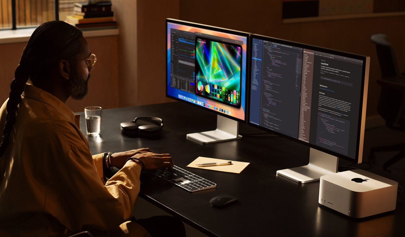 En professionel bruger, der arbejder med Mac Studio og to Studio Display-skærme