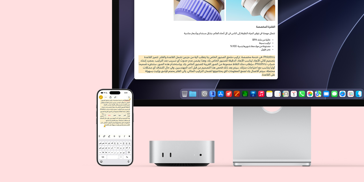 الجهة الأمامية لجهاز Mac mini، موضوع تحت شاشة Studio Display، جهاز iPhone موضوع على يمين الجهاز والشاشة، نص محدد مع أوامر القص والنسخ واللصق والتعبئة التلقائية في الجهة العلوية من iPhone يتطابق مع النص المظلل على الشاشة، في استعراض للحافظة العامة