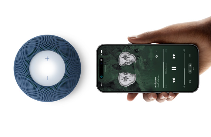 HomePod mini 2 y iPhone: una mano sostiene un iPhone junto a un HomePod mini 2 azul para usar la funcionalidad Handoff