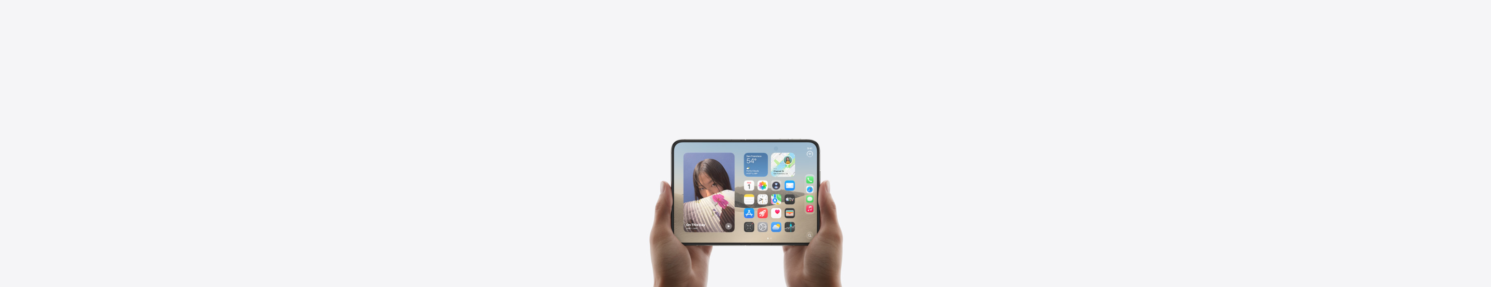 Dwa telefony iPhone Duo w układzie poziomym, trzymane w dwóch dłoniach, urządzenia są otwarte, na wewnętrznym wyświetlaczu widać ekran początkowy