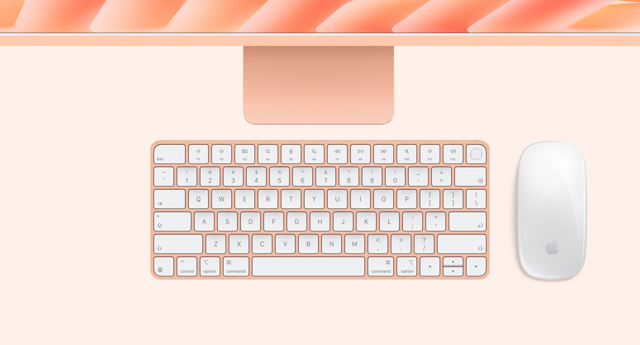 iMac i orange vist ovenfra med Magic Mouse og Magic Keyboard med Touch ID