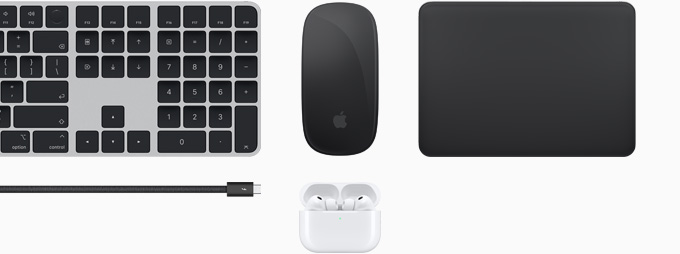 Collection of accessories including Magic Keyboard with Touch ID, Magic Mouse, Magic Track Pad, Thunderbolt 5 Pro cable, and AirPods Pro